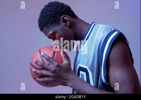 Serious basketball player with ball in studio Stock Photo