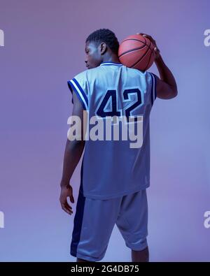 Basketball player poses with ball, back view Stock Photo