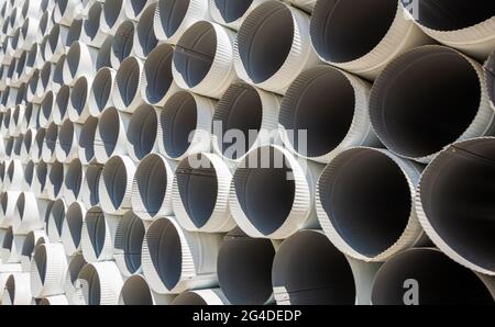 Downpipe warehouse. Steel pipes, parts for the construction of a roof drainage system in a warehouse. Stack of stainless steel pipes. Stock Photo