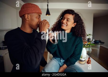 African American couple drinking coffee. Mixed race couple looking at each other in the kitchen at home. High quality photo Stock Photo
