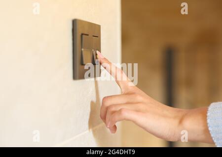 Close up of a woman hand pushing light switch at home Stock Photo