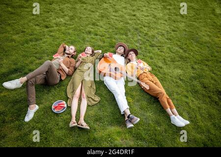 Friends lying together on the green lawn Stock Photo