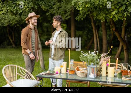 Two male friends talking during a lunch in nature Stock Photo