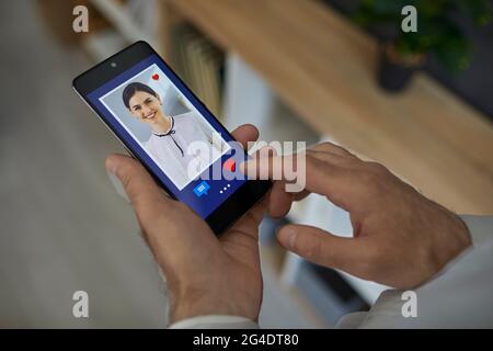 Man standing and looking through a photo of a young beautiful smiling European woman Stock Photo