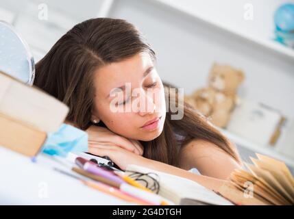 Teenage girl fell asleep when she was studying Stock Photo