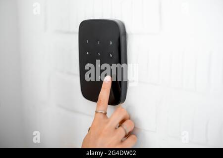 Entering code on the wireless alarm keyboard Stock Photo