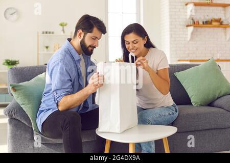 Couple looks inside the package containing the food they ordered from the fast food service. Stock Photo