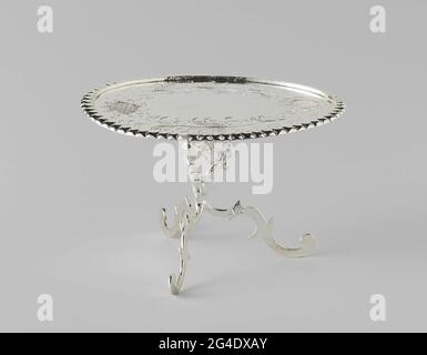 . Folding table on a tripod. The oval leaf has a processed edge and an engraved decoration of sunflowers and tendrils. The leaf rests on three cast gridides, which passes into the tripod. The table is marked: STK. = Amsterdam, Mt. = Frederik from STRANT I and an ax. Stock Photo