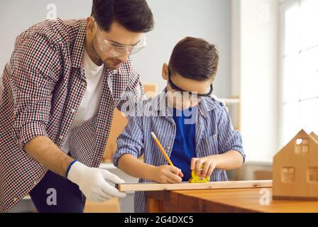 Father handyman and boy son child work at family carpentry home workshop Stock Photo