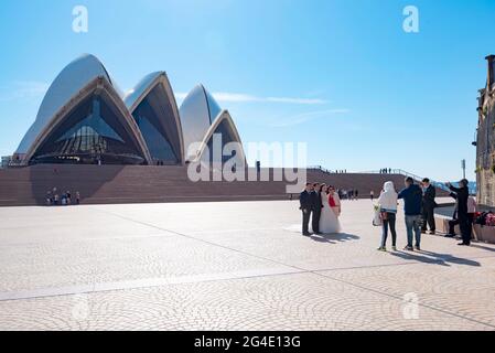 A bride and groom with family members being photographed on the forecourt of the Sydney Opera House in Australia Stock Photo