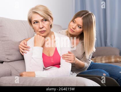 daughter comforts a sad mother Stock Photo