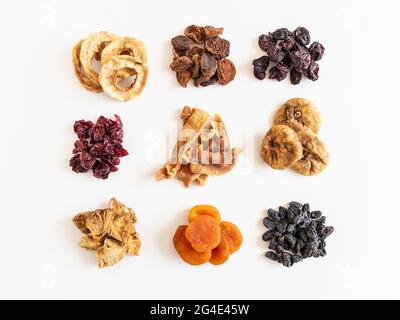 Various dried fruits heaps. Dried or sun-dried berries and fruits on white background. Vegan healthy natural snacks Stock Photo
