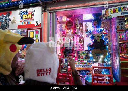 Tourists posing for photos in robots outside the Robot Restaurant in Tokyo, Japan Stock Photo