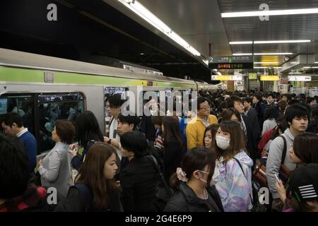 People getting on a metro train in Tokyo at rush hour Stock Photo