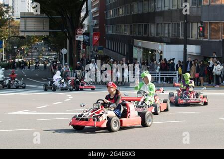 Tourists driving go karts while wearing costumes in Tokyo, Japan Stock Photo