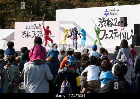 People watching a live action Power Rangers type performance on stage ...