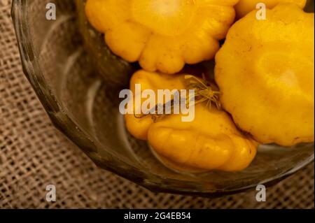 Pickled squash in a glass dish on a wooden table. Close-up Selective focus Stock Photo