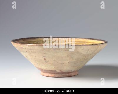 . Earthen works bowl, decorated with manganese brown and yellow, green and red sludge on a white sludge engine under transparent lead glaze. A deer and a band pseudo script on the inner wall. Stock Photo