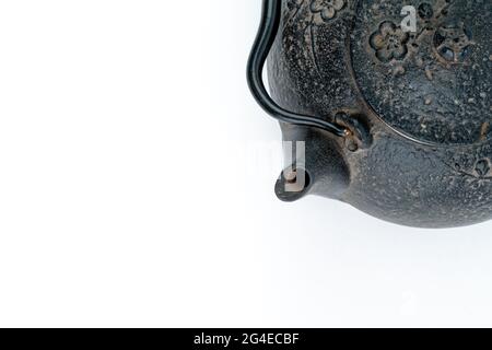 Vintage, black metal Japanese tea pot or kettle isolated on white background with a lot of white free space. Photographed directly from above. Minimal Stock Photo