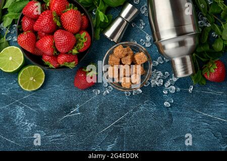 Food fresh ingredients for making lemonade, infused detox water or cocktail. Strawberries, lime, mint, basil, cane sugar, ice cubes and shaker on dark Stock Photo