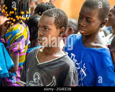 MBOUR, SENEGAL - DECEMBER Circa, 2020. Group of unidentified teenagers standing up in playground of the school , outdoors on a sunny summer day. Waiti Stock Photo