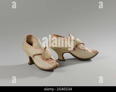 . Women's shoe from cream colored leather. Model: pointed nose, one cover page and two side sheets. Openings on either side of the foot. Raised valve on the instep. About the instep runs two flaps from each other from the side sheets on which a buckle can be attached .. The front of the heel runs straight down in a rounded corner from the GELENG. The side and back of the heel are fitted and covered with creamy leather leather. The heel has a dark brown edge leather of the rear flap. Side blades and covered sheet lined with cream colored leather. The insole is made of brown leather. Between the Stock Photo