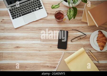 Smartphone, laptop and planner on table of business person or student, view from the top Stock Photo