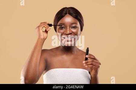 Portrait Of Happy Attractive Black Woman Applying Mascara On Eyelashes Stock Photo