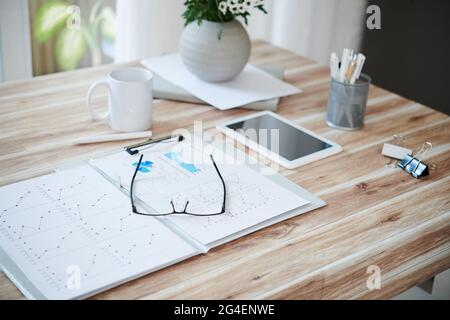 Opened folder with sales reports and glasses on table of entrepreneur Stock Photo