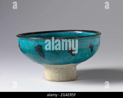 . Come from quartz frying goods decorated with a stylized blooming plant in black under a monochrome transparent turquoise glaze. Stock Photo
