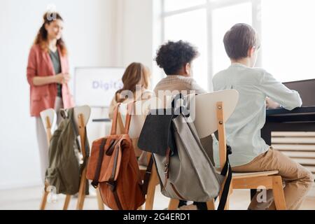 Back view at group of children sitting in row and using computers during IT lesson in school Stock Photo