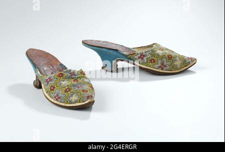 . Mule with front sheet of silk embroidery onto grid, with pattern of blue ster flowers on yellow fond with green network with red diamonds and white dots. Model: wide forefoot, pointed point. The heel is halfway through the Geleng and is covered with blue roughly leather. On the edge of the heel are white stitching. The front of the heel runs straight down in a rounded angle from the beginning of the Geleng. The back of the heel runs straight down in a rounded corner. The course of the back of the heel to the sides of the heel goes in a corner. Cover sheet lined with ivory white glacer. A ban Stock Photo