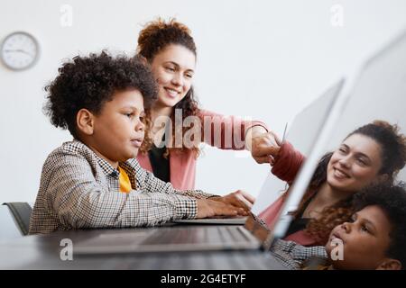 African american female teacher with digital tablet teaching in the ...