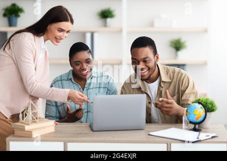 Travel Agent Offering Vacation Tour For African Couple In Office Stock Photo