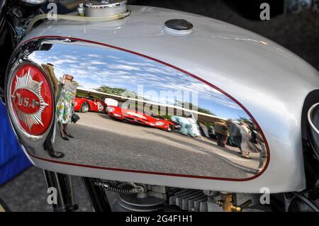 Vintage BSA motorcycle chrome fuel tank reflecting people and cars in the paddock area at the Goodwood Revival vintage event, West Sussex, UK Stock Photo