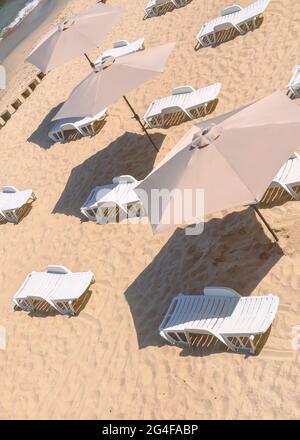 Empty deck chairs and sun umbrellas on a sandy beach. Stock Photo