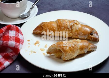 Almond croissant on plate with coffee cup, Germany Stock Photo