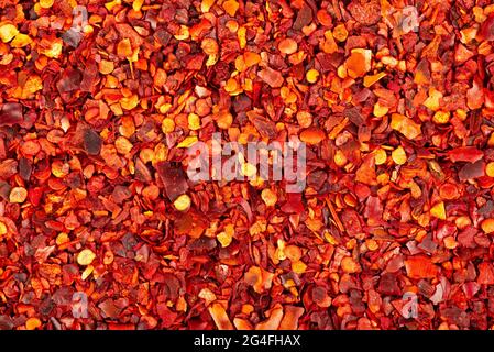 Dried red chili flakes with seeds background. Chopped chilli cayenne pepper. Spices and herbs. Stock Photo