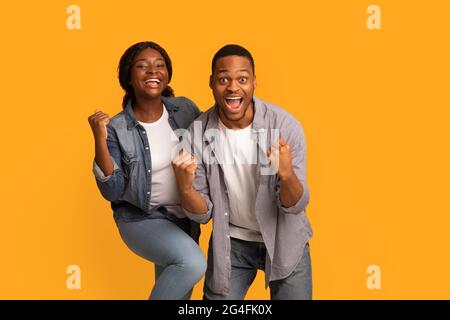 Big Win. Happy Excited Black Couple Celebrating Success With Raised Fists Stock Photo