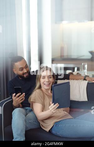 Happy excited young couple watching surprising final episode of show on digita tablet Stock Photo