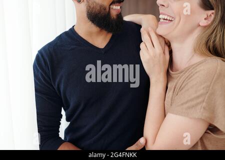Cropped image of happy laughing young couple hugging and looking at each other Stock Photo