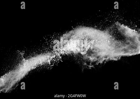 White dust particles splashing. Freez motion of talcum powder burst in dark background. Stock Photo