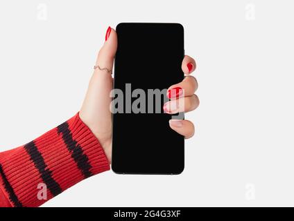 Manicured womans hand holding smartphone with blank screen. Stock Photo