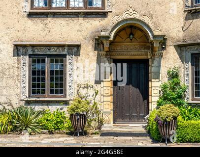 Front door of How Hill house in Norfolk UK with decorated window and door frames and arched stone canopy Stock Photo