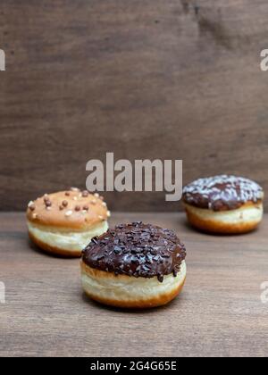 Delicious glazed chocolate donuts on wooden background Stock Photo