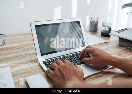 Hands of programmer coding on laptop at home or testing new program Stock Photo