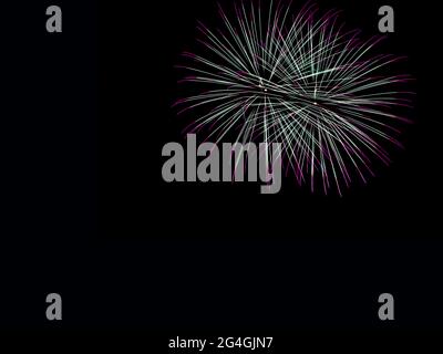 Large fireworks display in a night sky. Colorful explosions isolated on black background - wallpaper, backdrop. Room for text. Stock Photo