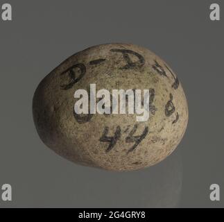 This stone was collected by an American soldier during the D-Day landings in northern France during World War II, and sent to African-American teacher and historian Hattye Thomas Yarbrough. Small circular black-flecked white rock with the inscription: [D-DAY / JUNE 6, / 44] written in black marker. This rock was retrieved from a Normandy beach on D-Day, June 6, 1944, by Master Sergeant Wallace B. Jackson of the 320th Barrage Balloon Battalion and sent to Hattye T. Yarbrough, an educator, wife of a veteran and archivist of Black history. Stock Photo