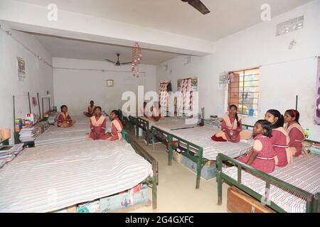 LANJIA SAORA TRIBE. Interior of girls hostel dormitory room serves both as studying and sleeping area. Puttasingh village in Odisha, India