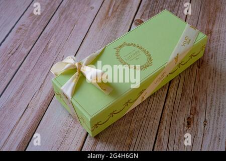 Nice, France - 18.06.2021: Famous French Macaroons from Laduree store. A green special gift box on a wooden background. Assorted Laduree Macaroons in the gift box. High quality photo Stock Photo
